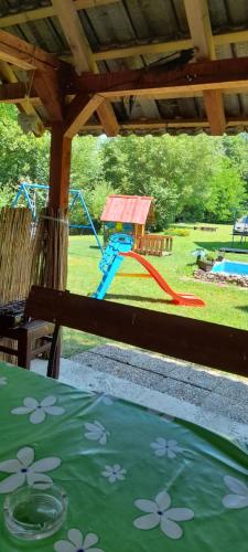 a kite in a yard with a playground at Vikendica na Jazu in Kosjerić