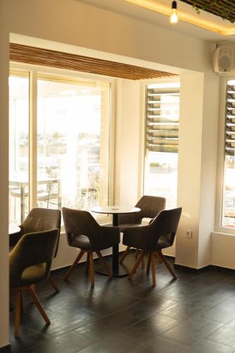 a dining room with a table and chairs and windows at D8 B&B in Zadar