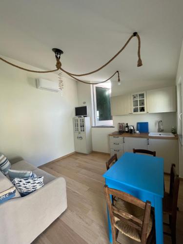 uma sala de estar com uma mesa azul e uma cozinha em VistaMare & Relax Cinque Terre SeaView & Relax Cinque Terre em Vernazza