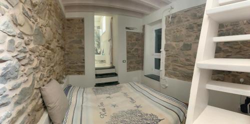 um quarto com uma cama e uma parede de pedra em VistaMare & Relax Cinque Terre SeaView & Relax Cinque Terre em Vernazza