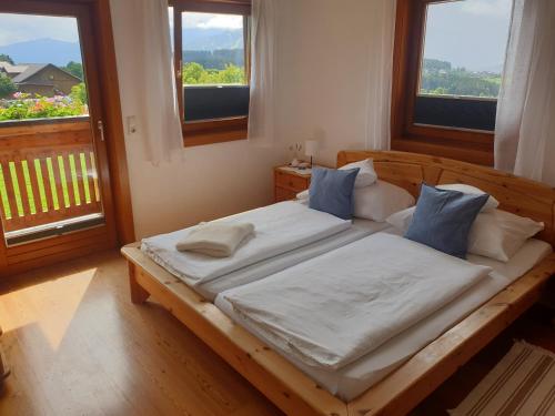 a bedroom with a wooden bed with white sheets and blue pillows at Bergführerhaus in Ramsau am Dachstein