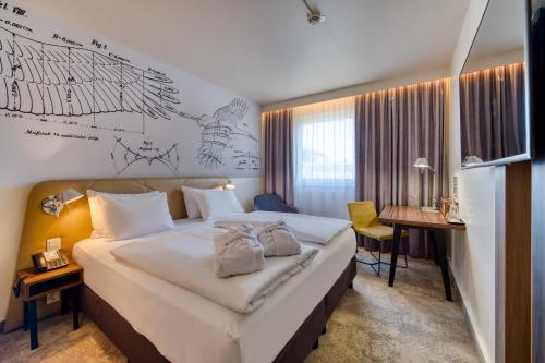 um quarto de hotel com uma cama grande e uma secretária em Mercure Hotel Berlin City em Berlim