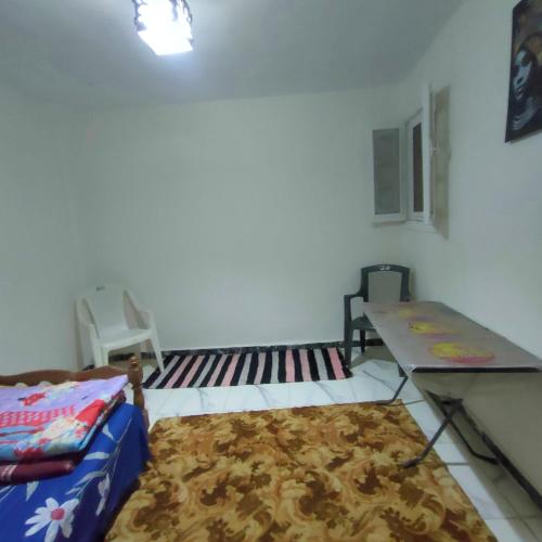 een kamer met een bed, een tafel en een tapijt bij Egyptian Hostel in Alexandrië