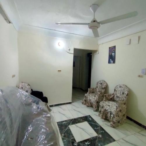 een woonkamer met stoelen en een plafondventilator bij Egyptian Hostel in Alexandrië
