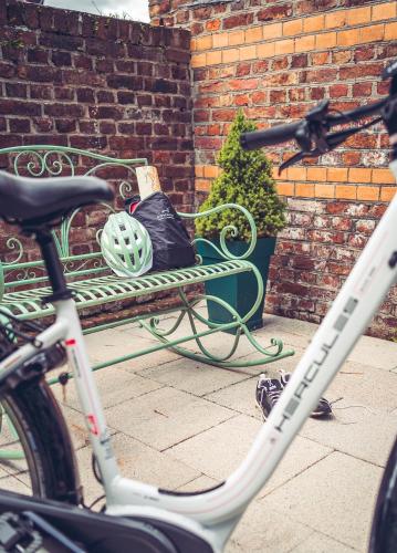 a bike parked next to a bench with a helmet at Hotel Villa Sanct Peter in Bad Neuenahr-Ahrweiler