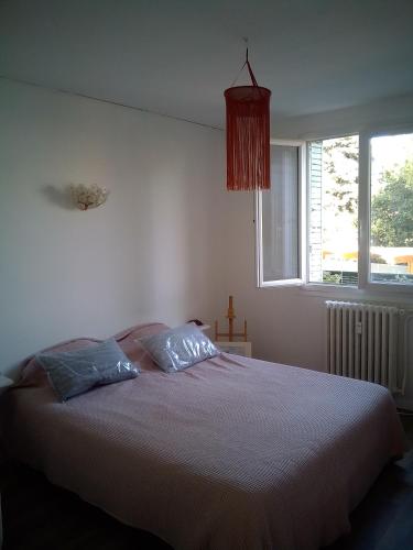 - une chambre avec un lit avec deux oreillers et une fenêtre dans l'établissement pont de l'aube, à Avignon