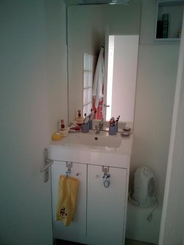 une salle de bain blanche avec un lavabo et un miroir dans l'établissement pont de l'aube, à Avignon