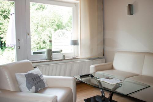 a living room with a couch and a table and a window at Meislahnhof Fehmarn in Fehmarn
