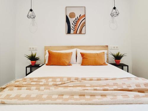 a bedroom with a large bed with orange pillows at Bilbao APARTAMENTOS Zorroza in Bilbao