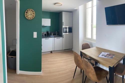 una cucina e una sala da pranzo con tavolo e sedie di Duplex type Loft centre ville * clim * WIFI * Haut de gamme * ad Angoulême