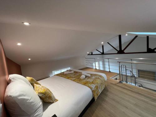 una camera da letto con un letto grande in una stanza di Duplex type Loft centre ville * clim * WIFI * Haut de gamme * ad Angoulême
