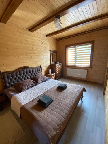 a bedroom with a large bed in a wooden room at Tomashchuk resort in Vorokhta