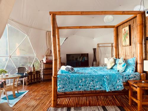 1 dormitorio con 1 cama con marco de madera en Glamping Dome Dauin Beach Resort, en Dauin