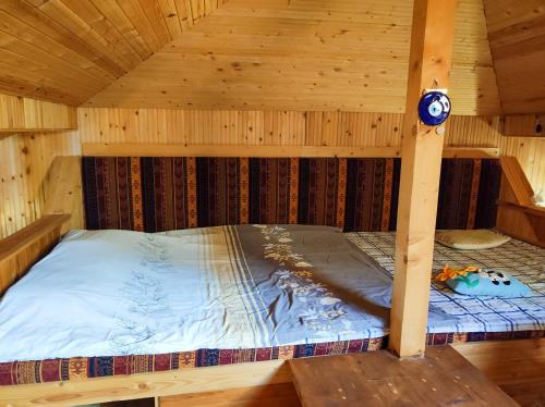 una cama dentro de una cabaña de madera en Терасите - Къща 1, en Ribaritsa