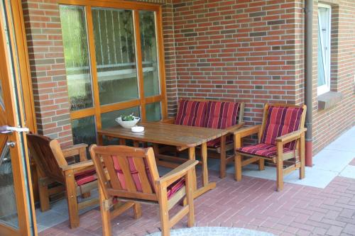 a wooden table and chairs on a patio at Pension Wilken in Bad Zwischenahn