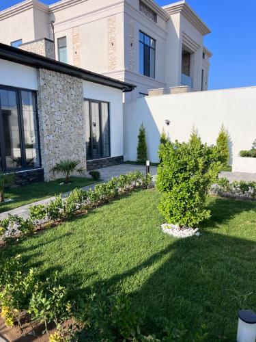 a house with a lawn in front of it at Villa deluxe in Baku