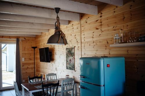 a kitchen with a blue refrigerator and a table at Domki Wielka Woda in Dywan