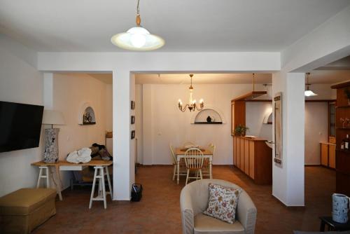 sala de estar y cocina con mesa y sillas en GTK Santorini Perivolos Beach House, en Perivolos