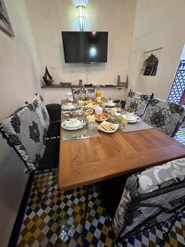 une table en bois avec des assiettes de nourriture dans l'établissement DAR SEFFAH au cœur de la Médina, à Fès