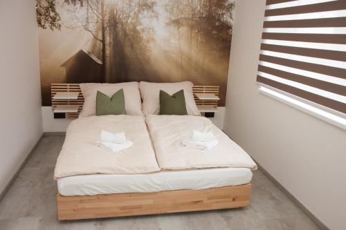 1 cama en un dormitorio con una pintura en la pared en Apartmán Devítka Resort pod Špičákem, en Smržovka
