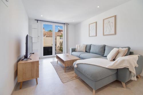 a living room with a couch and a tv at Deux suites haut standing duplex proche St. Tropez in Cogolin