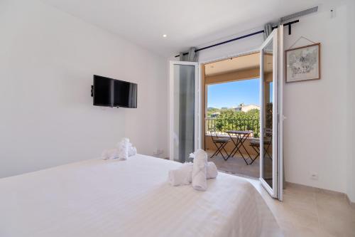 a bedroom with a white bed with a sliding glass door at Deux suites haut standing duplex proche St. Tropez in Cogolin