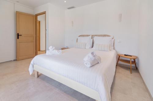 a bedroom with a white bed with towels on it at Deux suites haut standing duplex proche St. Tropez in Cogolin