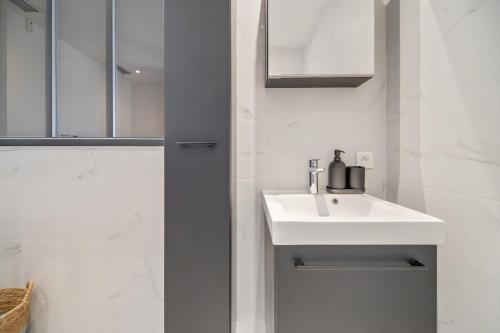 y baño blanco con lavabo y ducha. en Deux suites haut standing duplex proche St. Tropez, en Cogolin