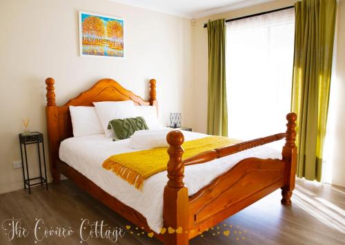 a bedroom with a large wooden bed and a window at Corner Cottage in Dandenong