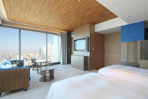a bedroom with a bed and a tv and a table at Nagoya Prince Hotel Sky Tower in Nagoya