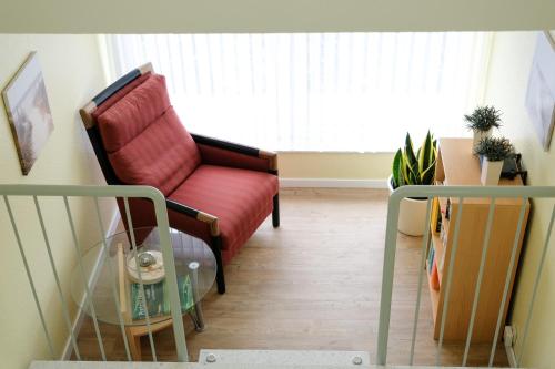 a living room with a red chair and a window at Pension Wilken in Bad Zwischenahn