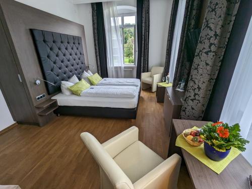 a hotel room with a bed and a table and chairs at Badhotel Bad Brückenau in Staatsbad Brückenau