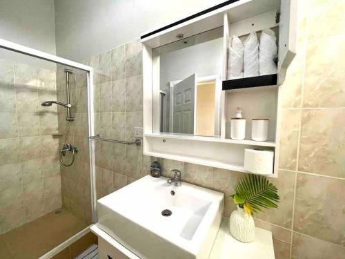 a bathroom with a sink and a shower and a mirror at Tropical getaway villa in Pereybere