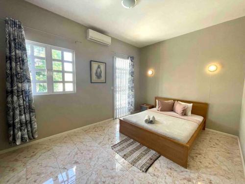 a bedroom with a bed and a window at Tropical getaway villa in Pereybere