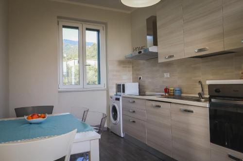 a kitchen with a table and a sink and a dishwasher at Appartamento nuovissimo con parcheggio gratuito in Massa