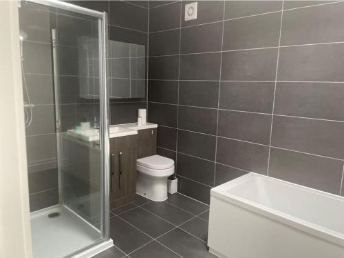 a bathroom with a shower and a toilet and a sink at Spacious City Centre Apartment near Lakeside in Stifford