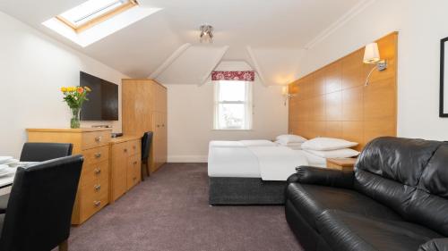 a bedroom with a bed and a couch at Teddington Lodge in Teddington