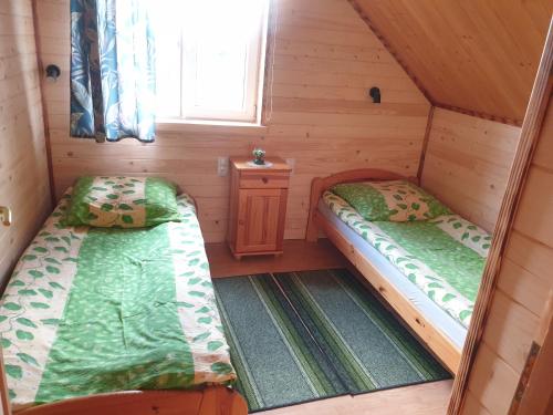 - une petite chambre avec 2 lits dans une cabine dans l'établissement Domek w Bieszczadach u Ani Apartament 3, à Uherce Mineralne