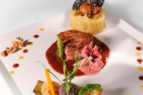 a white plate with some food on it at Hôtel & SPA Château de La Côte - Brantôme in Biras