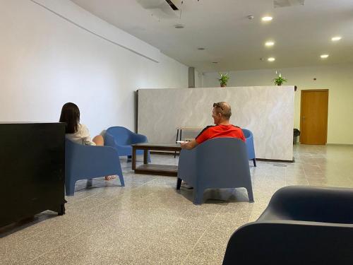 Ein Mann und eine Frau sitzen auf Stühlen in einem Zimmer in der Unterkunft Casa Augusta 3 in Braga