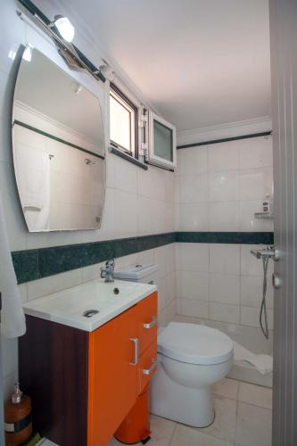 a bathroom with a toilet and a sink and a mirror at Bourtzi View Villa in Nafplio