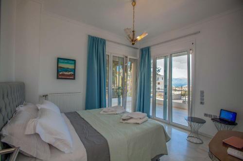 a bedroom with a bed and a large window at Bourtzi View Villa in Nafplio