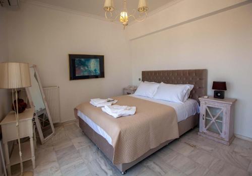 a bedroom with a bed with towels on it at Bourtzi View Villa in Nafplio