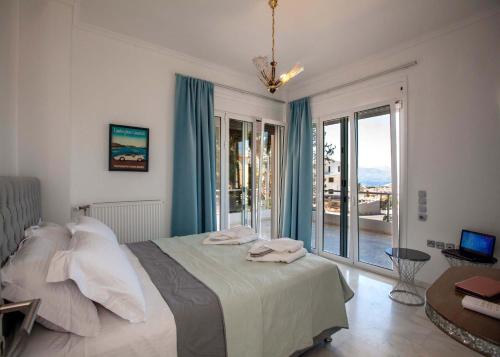 a bedroom with a bed and a large window at Bourtzi View Villa in Nafplio