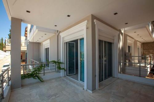 a balcony of a house with glass doors at Bourtzi View Villa in Nafplio