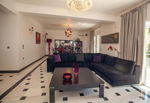 a living room with a couch and a coffee table at Bourtzi View Villa in Nafplio