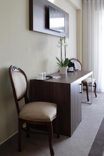 a desk with a chair in a room at Hotel McPietroasa in Haleş
