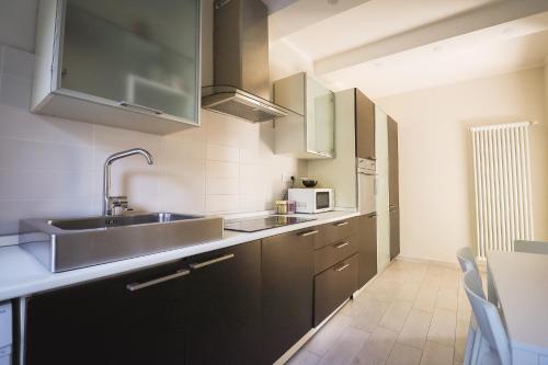 a kitchen with stainless steel cabinets and a sink at Appartamento nuovissimo con parcheggio gratuito in Massa