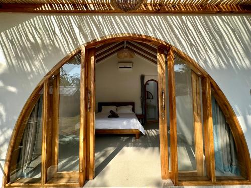 une chambre avec un lit à l'intérieur d'une maison en verre dans l'établissement Rumah Canaria Bungalow, à Gili Trawangan