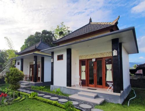 a small house with a green yard at Batur Happy House in Kintamani